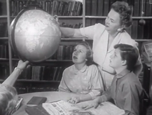 In the library looking at a globe